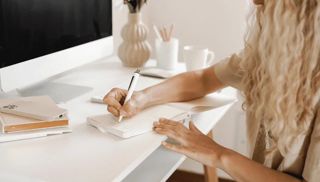 A woman enjoying social media while sipping coffee at a table.